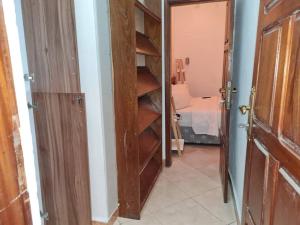 Un armario con estantes de madera y una habitación con una cama. en 2 Bedroom Appartement in the City, en Kinshasa