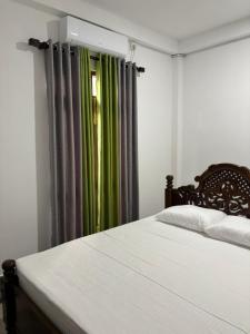 Villa Kia Ora في غالي: غرفة نوم بسرير ونافذة مع ستائر