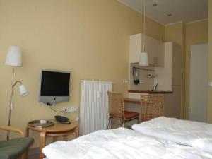 een slaapkamer met een bed en een bureau met een televisie bij Appartement mit skandinavischem Flair in Granzow +17 foto's