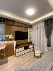 a bedroom with a bed and a television in a room at Apartment in bairro Fazenda, Itajaí, 2 bedrooms with ocean view in Itajaí