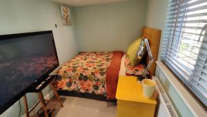 a bedroom with a bed and a flat screen tv at Quiet Loft Double Room forty-five minutes by train to London Liv Street in Braintree
