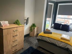 um quarto com uma cama, uma cômoda e uma janela em Allon Manor De'Grey em Hull