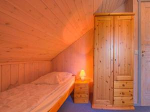 a small bedroom with a bed and a cabinet at Gemütliches Ferienhaus im skandinavischen Stil in Granzow