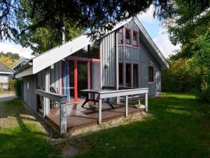 a house with a picnic table on a deck at Gemütliches Ferienhaus im skandinavischen Stil in Granzow