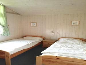 twee eenpersoonsbedden in een kamer met een raam bij Ferienhaus mit Sauna im Ferienpark Mirow in Granzow