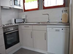 a white kitchen with a sink and a stove at Ferienhaus im skandinavischen Stil in Granzow