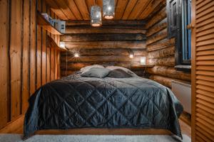 una camera con un letto in una baita di tronchi di Villa Kuurupiilo a Kuusamo