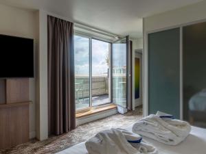 ein Hotelzimmer mit einem Bett und einem großen Fenster in der Unterkunft Novotel Paris Gare De Lyon in Paris