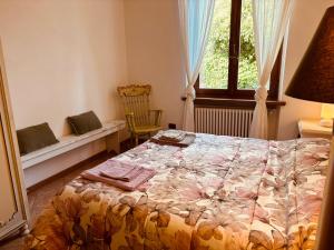 a bedroom with a bed and a window and a chair at Antica Fiera in Caprese Michelangelo