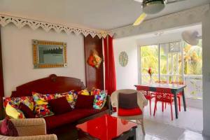 a living room with a red couch and a table at Chez Ti Julio - Appartment Premium in Sainte-Anne