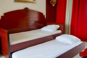 two twin beds in a room with red curtains at Chez Ti Julio - Appartment Premium in Sainte-Anne