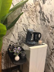 アルルにあるWhy Not Jacuzziの冷蔵庫の上に置かれた黒いコーヒーメーカー +2枚の写真