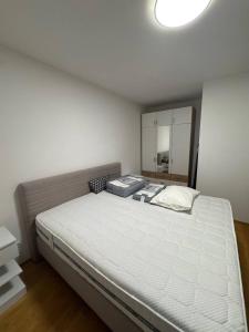 Schlafzimmer mit einem großen weißen Bett und einem Spiegel in der Unterkunft Premstätten Hofbauerweg 11 Ap 8 