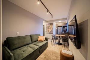 Design, Wi-Fi 7, 4 Hóspedes e Conforto Premium في Boa Vista: غرفة معيشة مع أريكة خضراء وطاولة