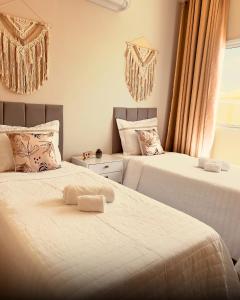 Un dormitorio con dos camas y una ventana. en SW Rustica Apartamentos, en Canoa Quebrada