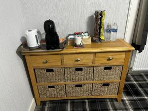 a wooden dresser with baskets on top of it at Glenshee Guest House in Golspie