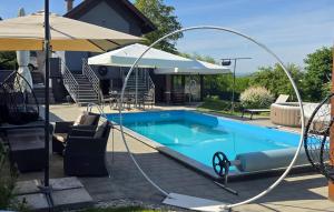 a swimming pool with a hose attached to a house at Gorgeous Home In Slavonski Brod With Sauna in Podvinje +14 photos