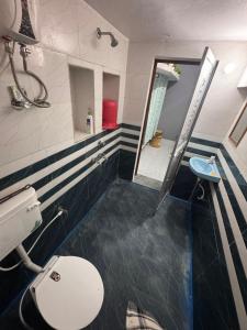 a bathroom with a toilet and a sink and a mirror at AP Homestay in Faizābād