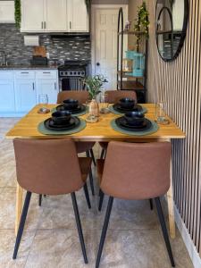 a kitchen with a wooden table with chairs at 20 Off The Jungle House 10 min Beach & FLL Airport in Fort Lauderdale +7 photos
