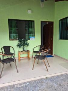 two chairs and a table in front of a building at suite confortavel temporada caraguatatuba in Caraguatatuba