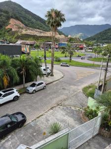 a street with cars parked in a parking lot at suite confortavel temporada caraguatatuba in Caraguatatuba