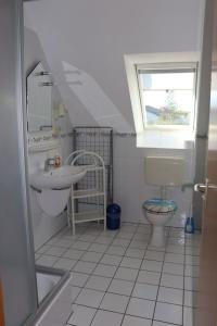 a bathroom with a sink toilet and a window at Baltique Fewo 3 in Glowe +3 photos