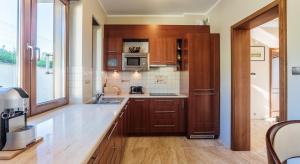 a kitchen with wooden cabinets and a counter top at Dom Na Stoku - Hillside Cottage Eliza in Szczawnica