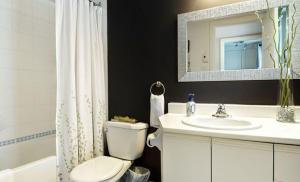 a bathroom with a toilet and a sink and a mirror at Hameau 28-41 studio in Stoneham