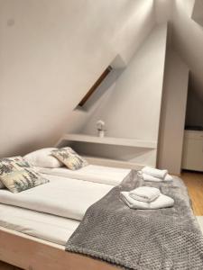 twee bedden op een zolderkamer met witte lakens en kussens bij Apartament Irys in Zakopane