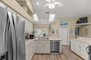 a kitchen with white cabinets and a stainless steel refrigerator at Citrus Springs Oasis-Rainbow River, Manatees, Golf in Citrus Springs