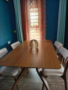 a dining room table with white chairs and a window at Kio Farm Retreat 2 in Kiserian