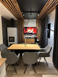 Un comedor con mesa y sillas y chimenea. en Arctic Glow Apartment 3, en Ivalo