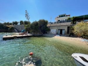 a boat in the water next to a beach at First Row to The Sea - Ideal for Families - Sea at Your Doorstep - House Sisko in Trogir