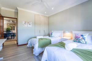 a room with three beds with white sheets at Amara Mountain View George in George