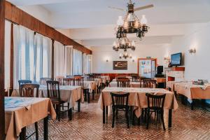 a dining room with tables and chairs and a chandelier at San Pedro Hotel in Río Ceballos
