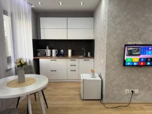 een keuken met een tafel en een tv aan de muur bij Квартира in Karagandy