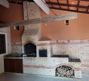 a brick fireplace in a house with a fire place at Sossego Ponta da Fruta in Vila Velha