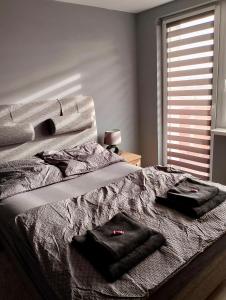 een slaapkamer met een bed met twee handdoeken erop bij Apartment Manhattan in Tarnowskie Góry