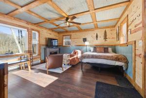 a bedroom in a log cabin with a bed and a kitchen at NEW! BEAR Necessities tiny home, outdoor theater! in Garrison