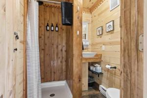 a wooden bathroom with a shower and a sink at NEW! BEAR Necessities tiny home, outdoor theater! in Garrison +41 photos