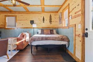 a bedroom with a bed in a wooden cabin at NEW! BEAR Necessities tiny home, outdoor theater! in Garrison