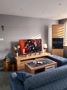een woonkamer met een bank en een flatscreen-tv bij Apartment Manhattan in Tarnowskie Góry