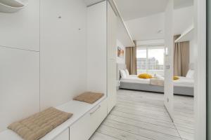 Premium Studio in OVO في فروتسواف: غرفة بيضاء بسريرين ومرآة