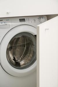 Premium Studio in OVO في فروتسواف: غسالة بيضاء مع فتح بابها