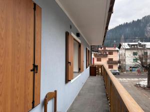 a building with a balcony with a view of a street at Casa Capon in Santo Stefano di Cadore