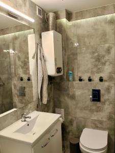 een badkamer met een witte wastafel en een toilet bij Apartment Manhattan in Tarnowskie Góry +14 foto's