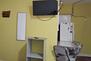 a room with a chair and a tv and a refrigerator at Casa Julia in Puerto Madryn