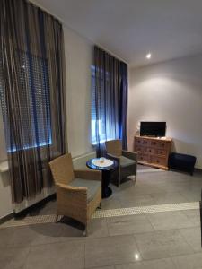 a living room with chairs and a table and a television at Ferienwohnung-Monteurwohnung-Parkplatz in Meine