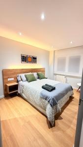a bedroom with a large bed and a wooden floor at Fogar de Breogan in A Coruña