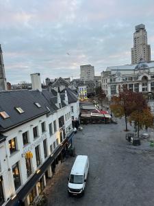una furgoneta blanca estacionada en un estacionamiento en una ciudad en Cozy Central Apartment with Cathedral View on the 3rd floor, en Amberes